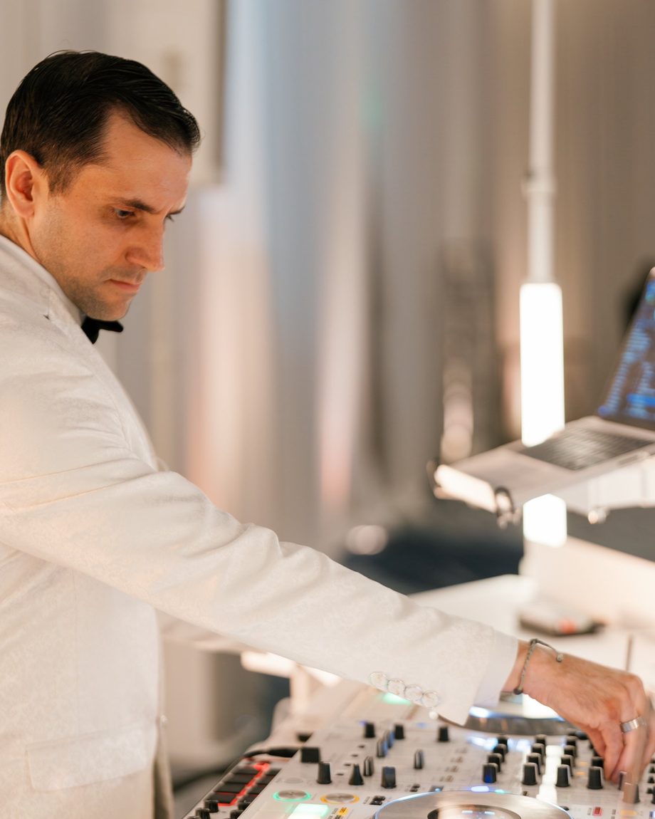 DJ Dayve in a white dinner jacket mixing