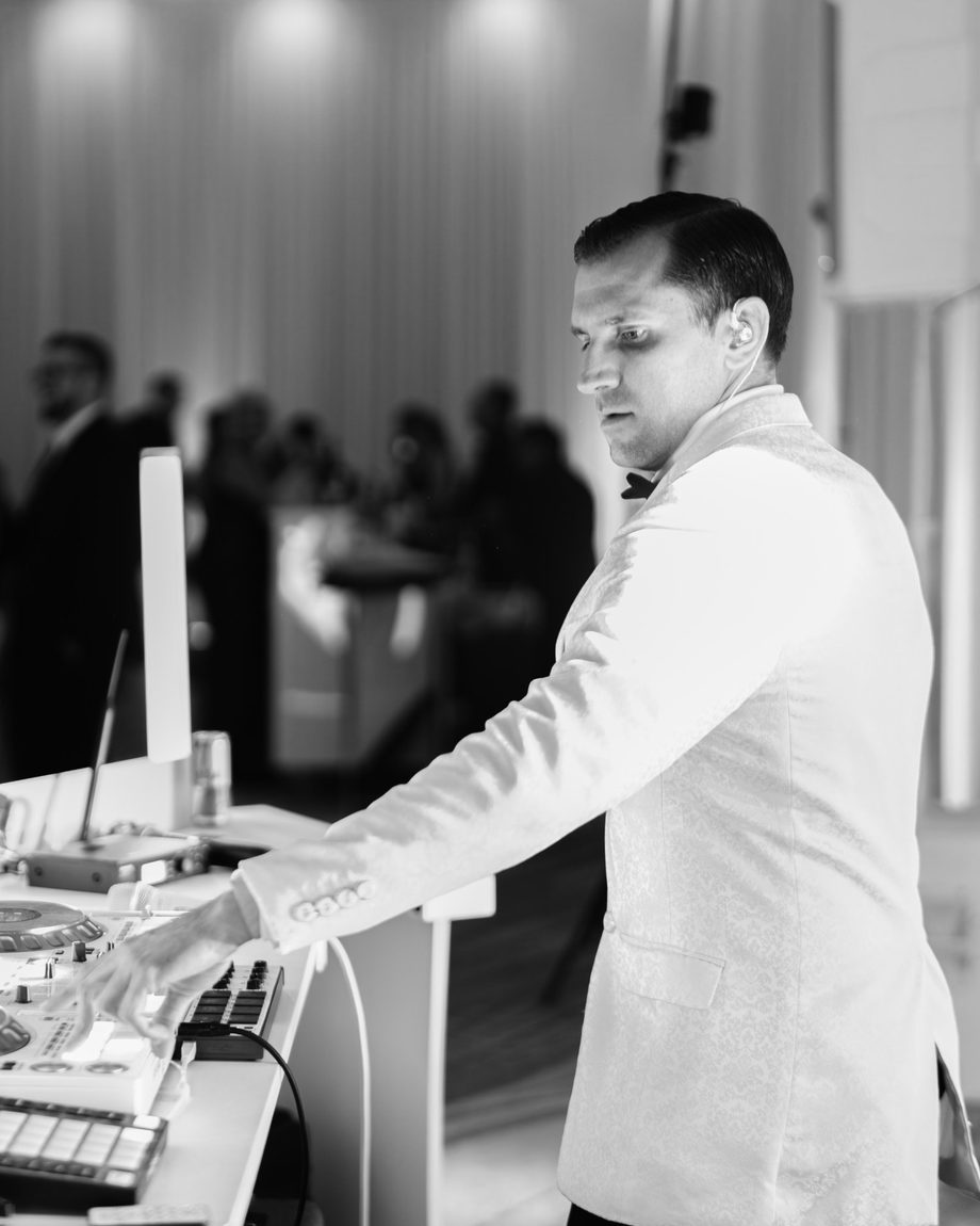 DJ Dayve at the booth during a reception, in black and white